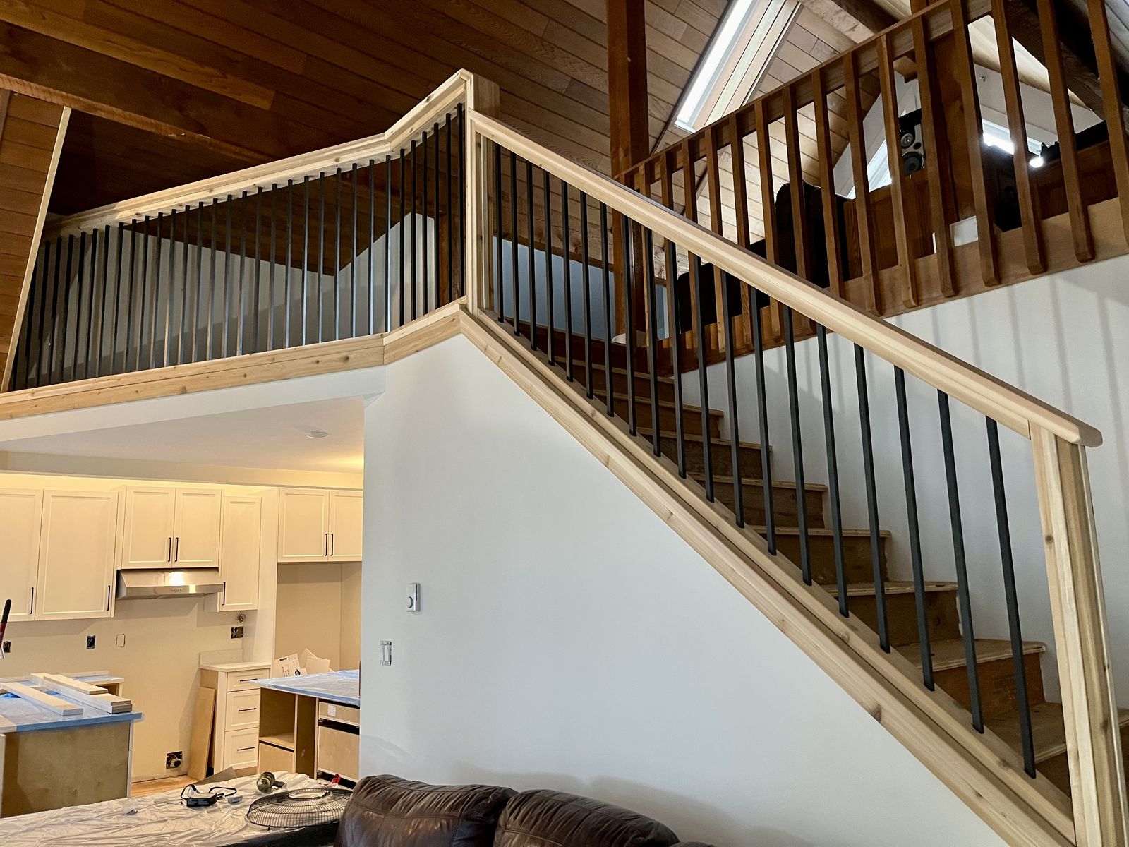 Staircase with wood handrail and black balusters