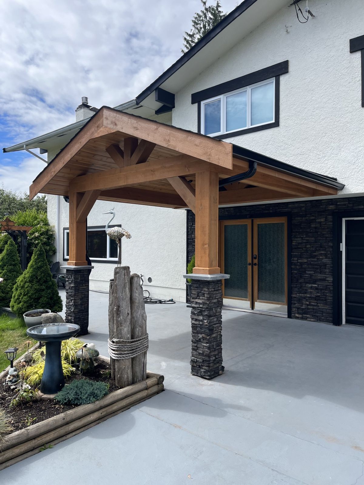 Cedar timber-frame portico with stone-clad columns